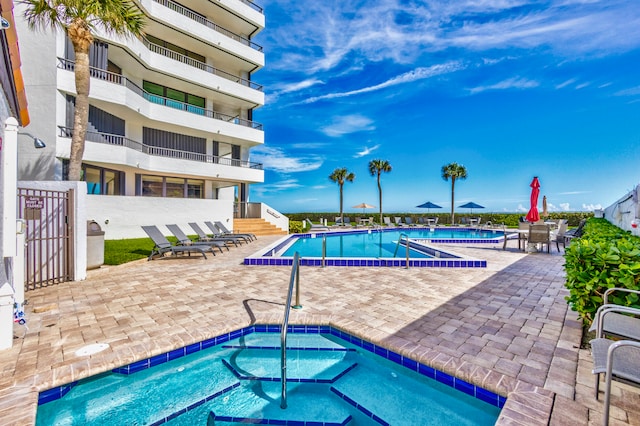 view of swimming pool with a hot tub and a patio