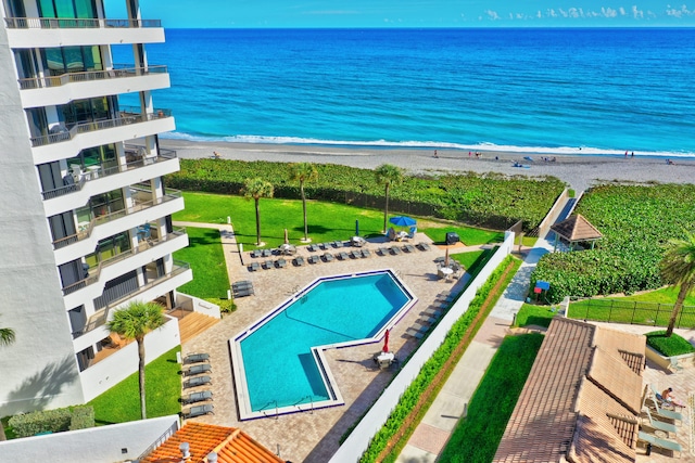 view of pool featuring a water view and a view of the beach