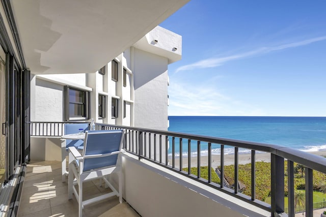 balcony featuring a water view and a beach view