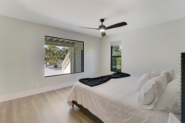 bedroom with light hardwood / wood-style floors, multiple windows, and ceiling fan