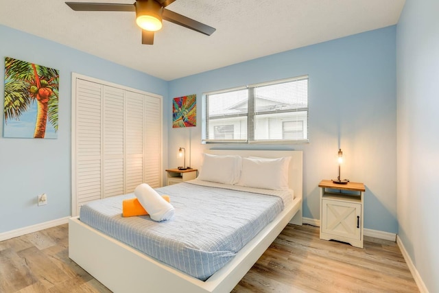 bedroom with ceiling fan, light wood-type flooring, and a closet