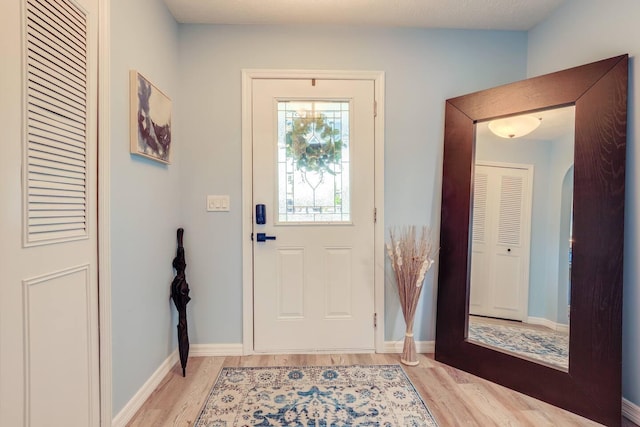 doorway to outside with light hardwood / wood-style floors and a textured ceiling