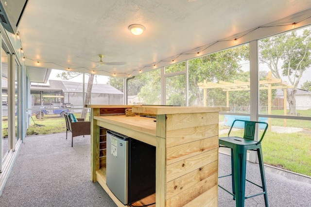 sunroom / solarium featuring ceiling fan