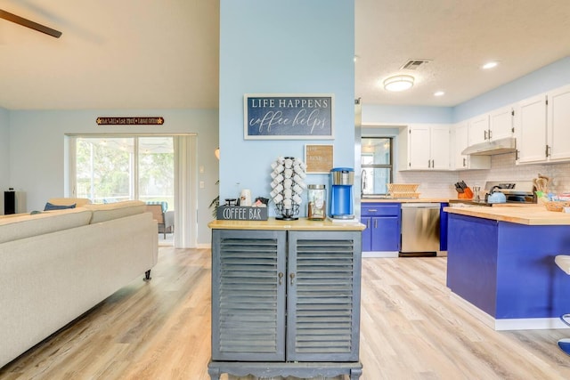 kitchen with tasteful backsplash, light hardwood / wood-style flooring, wooden counters, white cabinets, and appliances with stainless steel finishes