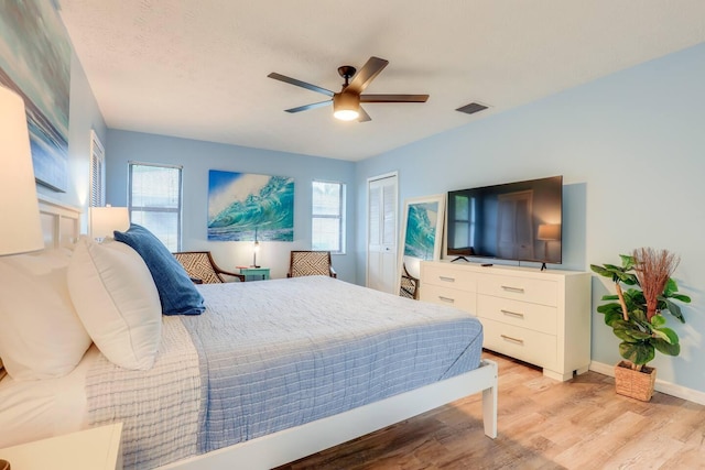 bedroom with multiple windows, ceiling fan, a closet, and light wood-type flooring