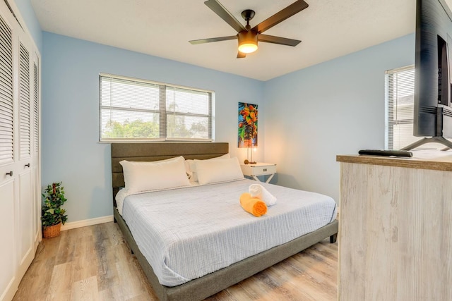 bedroom with light wood-type flooring, a closet, and ceiling fan