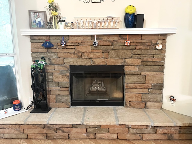 details featuring hardwood / wood-style flooring and a stone fireplace