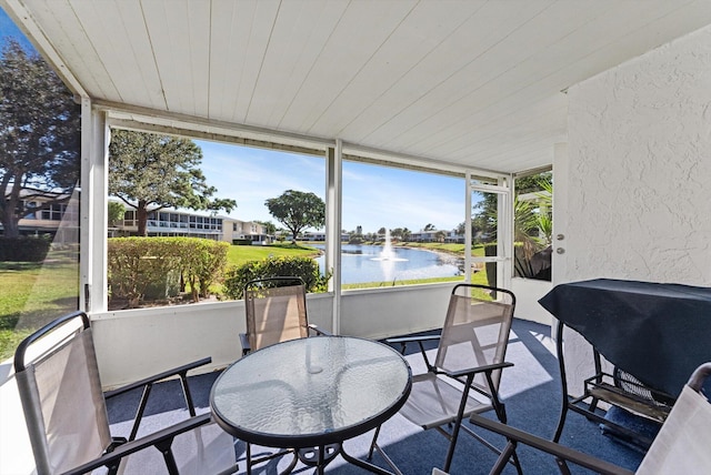 sunroom / solarium featuring a water view