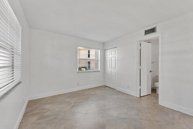 spare room with light tile patterned flooring and a textured ceiling