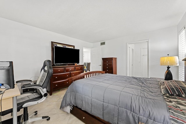 bedroom featuring a textured ceiling and light tile patterned flooring