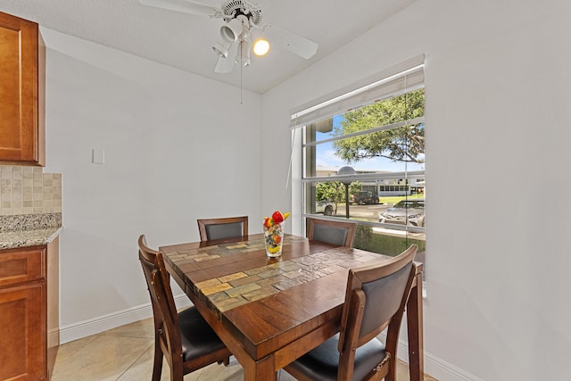 tiled dining room featuring a textured ceiling and ceiling fan