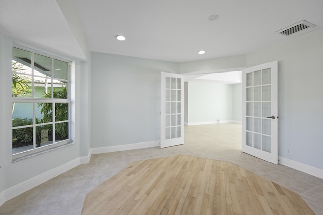 unfurnished room featuring french doors and light tile patterned floors