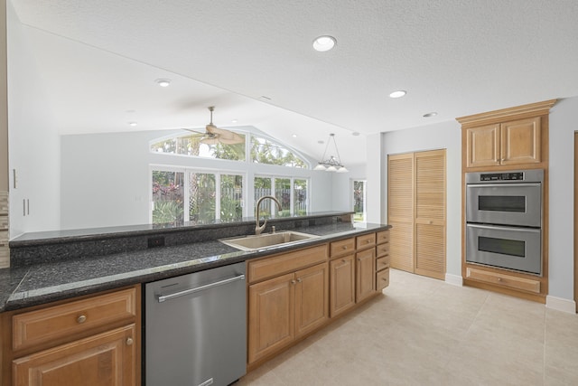 kitchen featuring stainless steel appliances, ceiling fan, sink, hanging light fixtures, and lofted ceiling