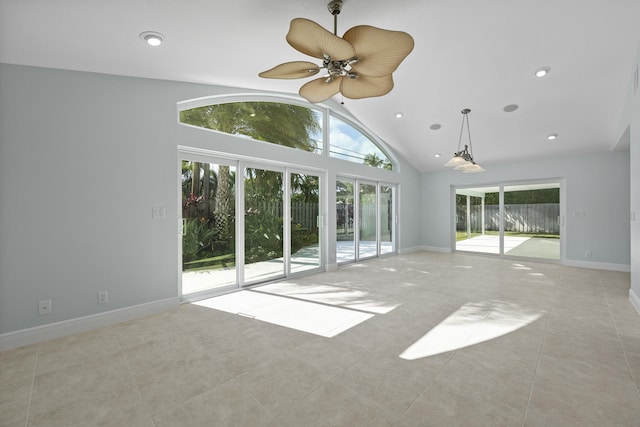 unfurnished living room featuring plenty of natural light, ceiling fan, light tile patterned flooring, and lofted ceiling