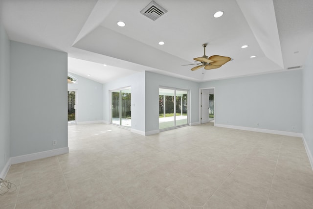 unfurnished room with light tile patterned floors, a raised ceiling, and ceiling fan