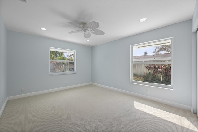 empty room featuring ceiling fan and light carpet