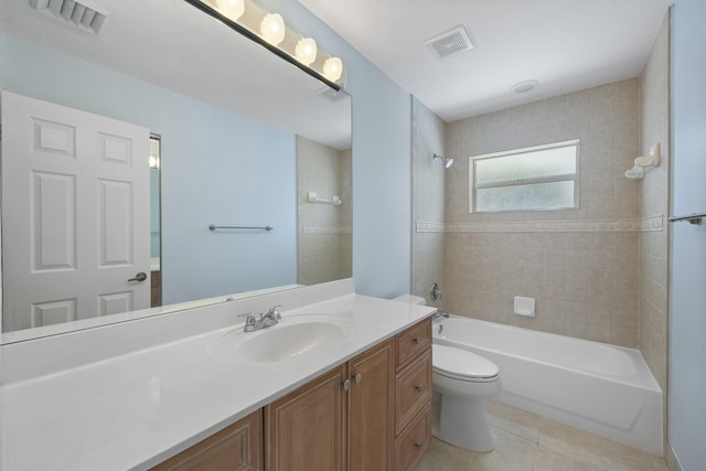 full bathroom with tile patterned flooring, vanity, tiled shower / bath combo, and toilet