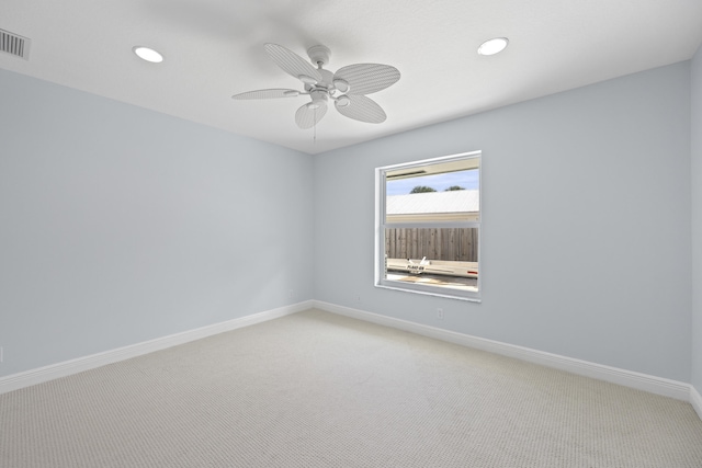 unfurnished room with light colored carpet and ceiling fan