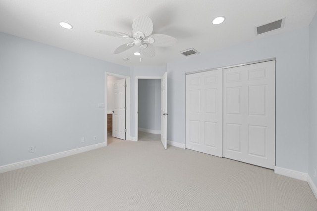 unfurnished bedroom featuring a closet, light colored carpet, and ceiling fan