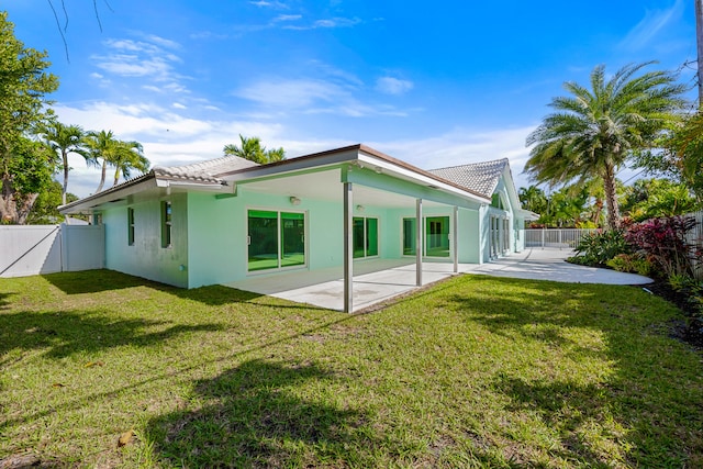 back of property featuring a yard and a patio