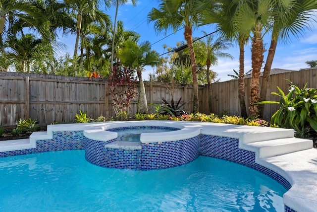 view of swimming pool with an in ground hot tub