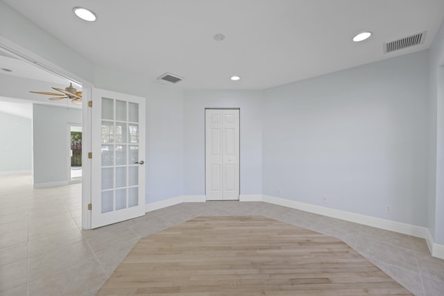 spare room with ceiling fan and light tile patterned floors