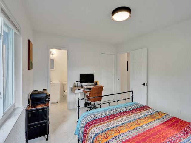 bedroom featuring ensuite bathroom and multiple windows