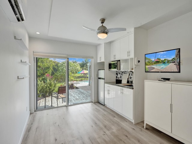 kitchen with ceiling fan, sink, white cabinets, and light hardwood / wood-style floors