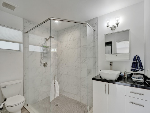 bathroom featuring vanity, toilet, and walk in shower