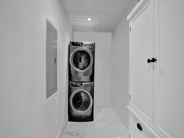 washroom with electric panel and stacked washer and dryer