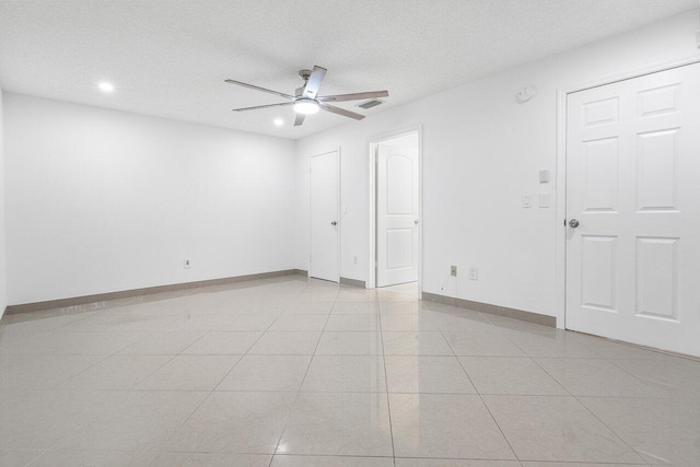 tiled spare room featuring ceiling fan and a textured ceiling