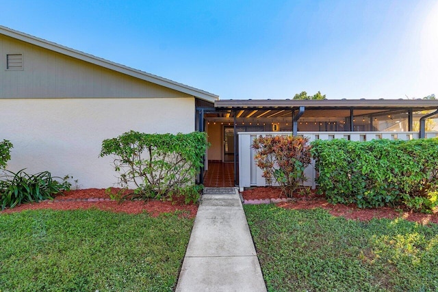 entrance to property featuring a yard