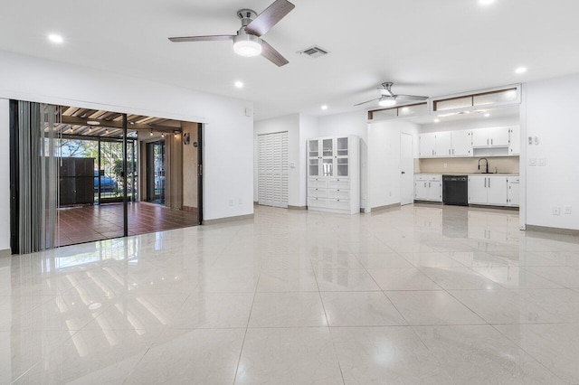 unfurnished living room featuring ceiling fan, sink, and light tile patterned floors