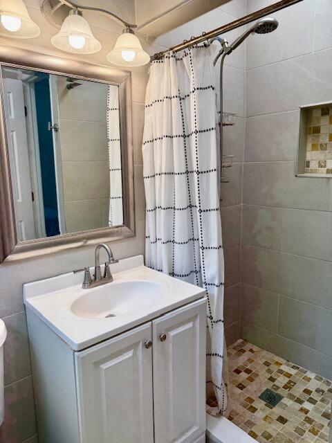 bathroom featuring curtained shower, toilet, and vanity