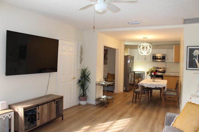 living room featuring ceiling fan and light wood-type flooring