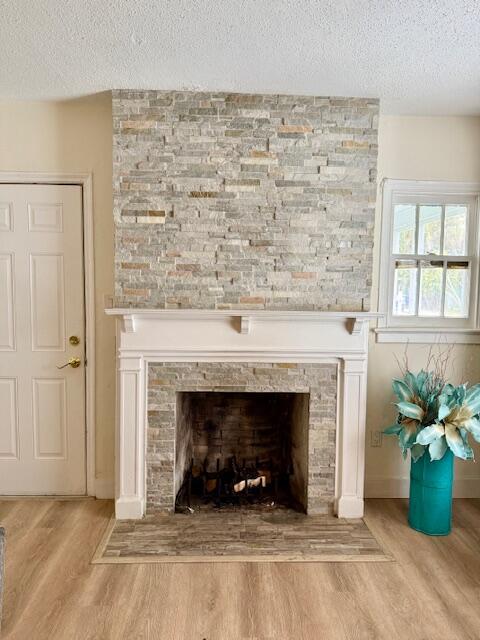 interior details with a textured ceiling, a fireplace, and hardwood / wood-style flooring