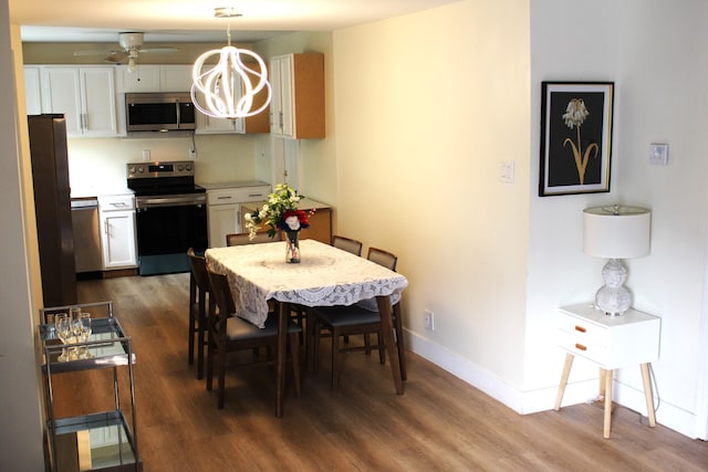 kitchen featuring ceiling fan, wood-type flooring, white cabinetry, hanging light fixtures, and appliances with stainless steel finishes