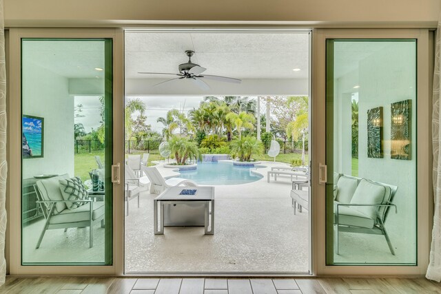 doorway to outside with ceiling fan and light hardwood / wood-style floors