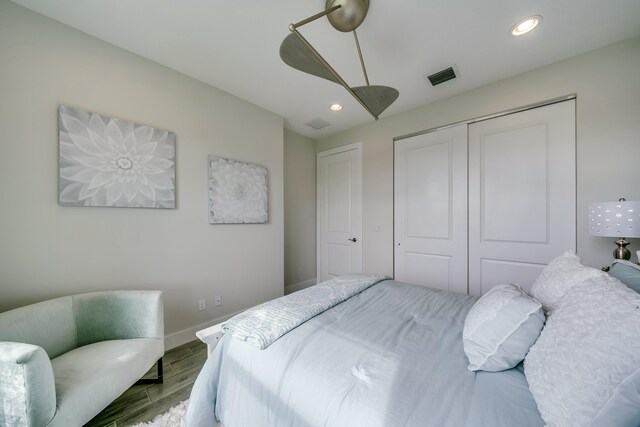 bedroom with ceiling fan, a closet, and parquet flooring