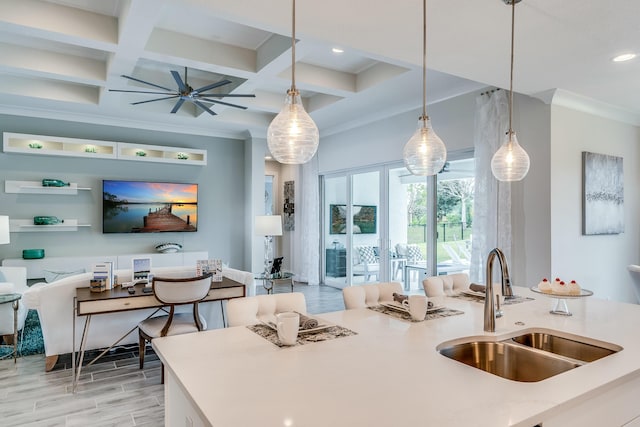 kitchen featuring beamed ceiling, hanging light fixtures, coffered ceiling, and sink