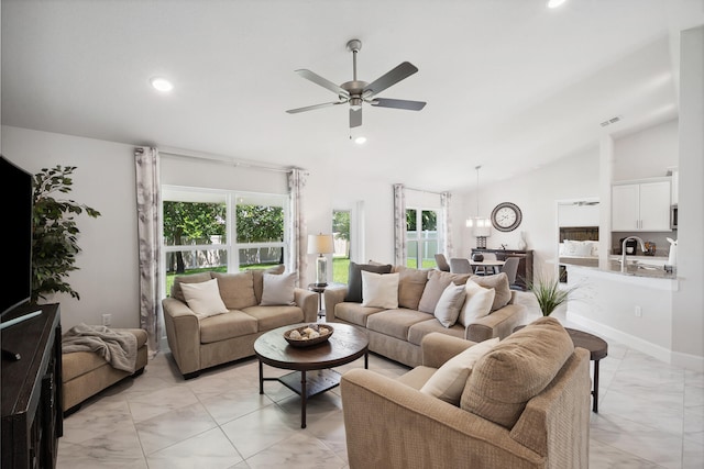 living room with ceiling fan, plenty of natural light, and vaulted ceiling