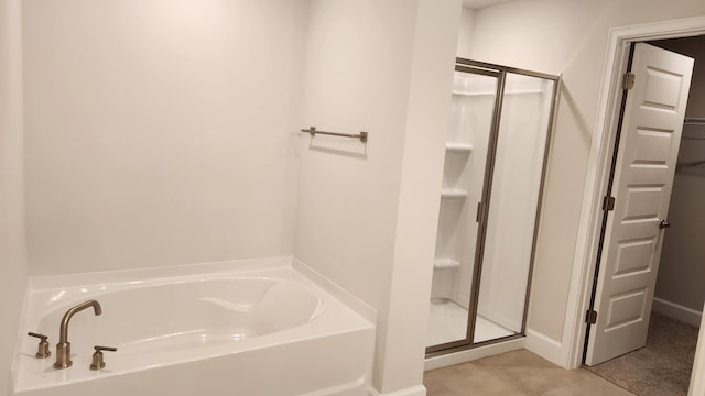 206 Riomar Dr, Port Saint Lucie, FL 34952 - full bathroom with a bath, baseboards, a spacious closet, and a stall shower
