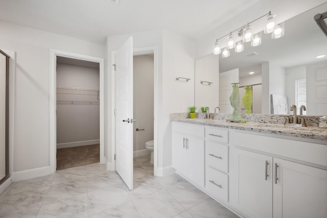 bathroom with vanity, an enclosed shower, and toilet