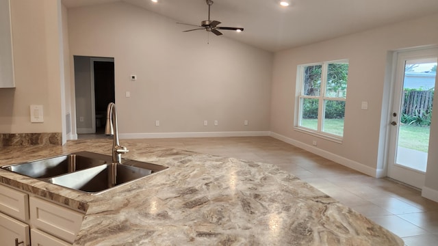 206 Riomar Dr, Port Saint Lucie, FL 34952 - kitchen featuring ceiling fan, light stone counters, light tile patterned floors, a sink, and white cabinetry