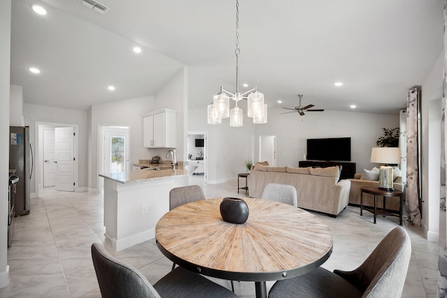 dining room with ceiling fan, lofted ceiling, and sink