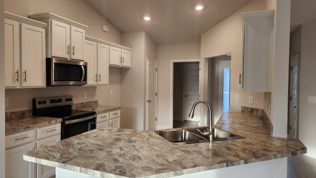 206 Riomar Dr, Port Saint Lucie, FL 34952 - kitchen featuring white cabinets, light stone counters, a sink, a peninsula, and appliances with stainless steel finishes