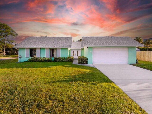 single story home with a garage and a front yard