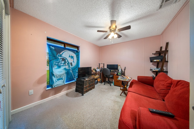 carpeted home office featuring ceiling fan and a textured ceiling