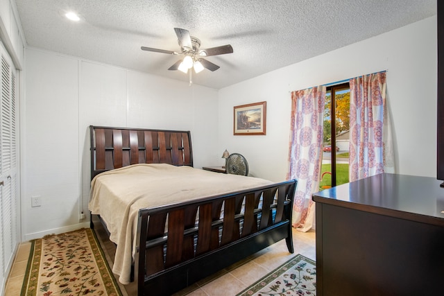 tiled bedroom featuring ceiling fan and a textured ceiling