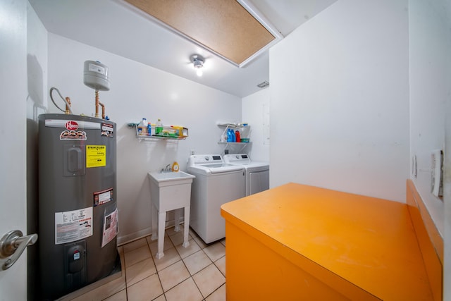 clothes washing area featuring light tile patterned flooring, electric water heater, and washing machine and dryer